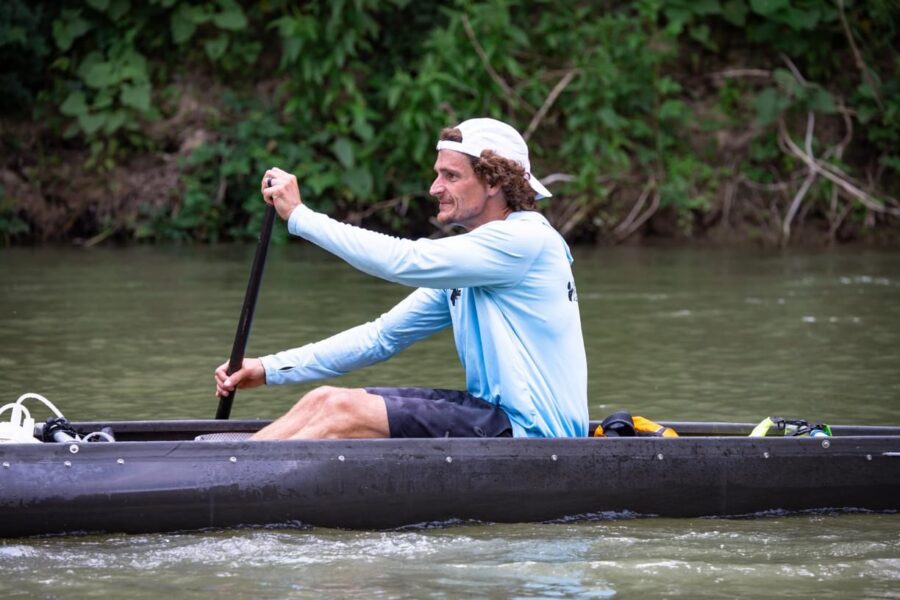 Spencer Fuller training in a racing canoe on a calm stretch of Texas river