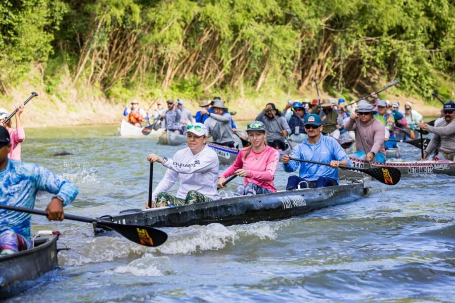Canoe racers paddling in a tight pack at the start of an ultra distance Texas river race