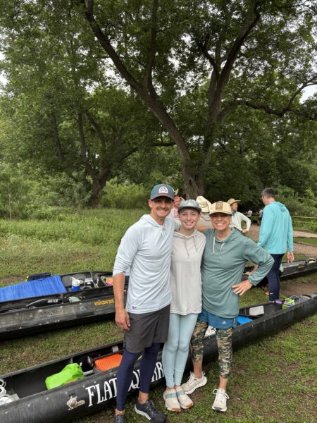 The Fuller Family standing together beside their boats before a Texas river race