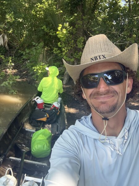 Spencer Fuller in an NBTX straw cowboy hat during a long distance canoe race in Texas.